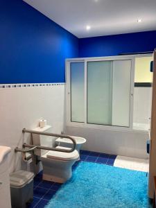 baño con aseo y pared azul en Quinta de Santana - Queimadas, en Furnas