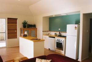 a kitchen with a white refrigerator and a counter at Ocean Mist Villa in Albany