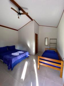 1 dormitorio con cama y banco. en Pousada Pedra Grande - SANA, en Macaé