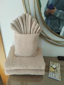 a stack of towels on a table in front of a mirror at Pensión Casa do Gallo Sarria in Sarria