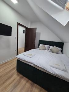a bedroom with a large bed with white sheets at Mrakovica 1935 in Prijedor