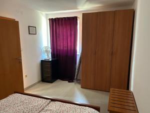 a bedroom with a bed and a closet and a window at Lucija in Karlobag