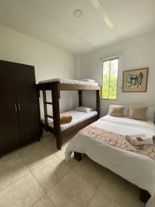 sypialnia z 2 łóżkami piętrowymi i oknem w obiekcie Mahalo Hostel w mieście Salento