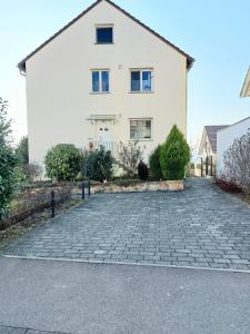 a white house with a driveway in front of it at Feel comfortable in Vaihingen an der Enz