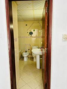 a bathroom with a toilet and a sink at Tranquil Haven King Bed Ensuite Fully Furnished Bedroom in Ajman 