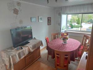 a living room with a table and a tv and a table and chairs at Feel comfortable in Vaihingen an der Enz