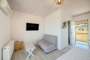un soggiorno con divano, TV e tavolo di Leonidas Resort a Ermioni