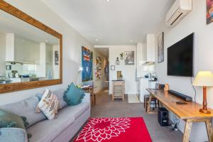 a living room with a couch and a table at Beachfront Studio Apartment in Frankston Melbourne in Frankston