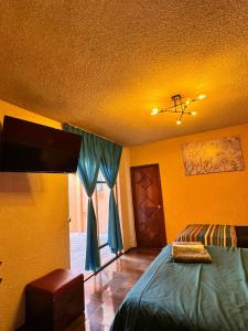 a bedroom with yellow walls and a bed with blue curtains at Hotel Diamantes in Orizaba