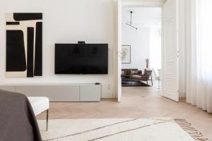 een woonkamer met een flatscreen-tv aan een witte muur bij München ganz zentral in München