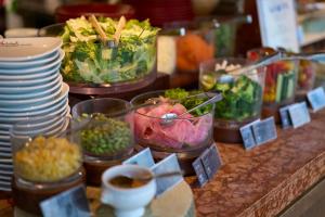 a counter with bowls of food and plates of food at Hotel Resol Akihabara in Tokyo