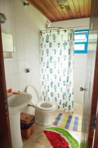 a bathroom with a toilet and a shower curtain at Vill Angeli in Gonçalves