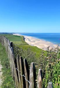 a wooden fence with a view of a beach at comme un air de chez soi in Calais