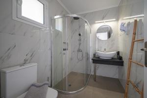 a bathroom with a shower and a toilet and a sink at Leonidas Resort in Ermioni