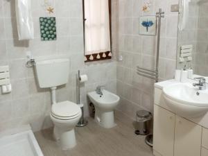 Baño blanco con aseo y lavamanos en B&B La Risorgiva, en Fivizzano