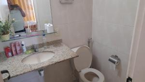 a small bathroom with a sink and a toilet at Apartamento com piscina Braga Cabo Frio in Cabo Frio +10 photos