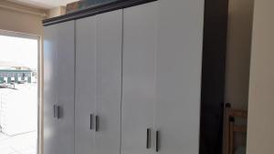 a white cabinet in a room with a window at Apartamento com piscina Braga Cabo Frio in Cabo Frio