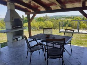 une terrasse avec une table, des chaises et une cuisinière dans l'établissement Kuća za odmor DIVA***, à Donja Stubica
