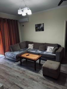 ein Wohnzimmer mit einem Sofa und einem Couchtisch in der Unterkunft Family Apartaments in Sarandë