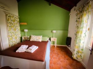 a green bedroom with a bed with towels on it at Cabañas Refugio del Ángel in Tandil