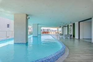 - une grande piscine d'eau bleue dans un bâtiment dans l'établissement Brand New Harmony Apartment with Pool, Gym and Spa in La Julia, à Saint-Domingue