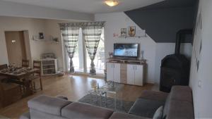 uma sala de estar com um sofá e uma televisão em Kuća za odmor DIVA*** em Donja Stubica