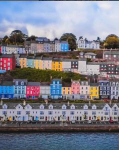 a group of colorful houses on a hill next to the water at Sea view Flat Cobh in Cobh