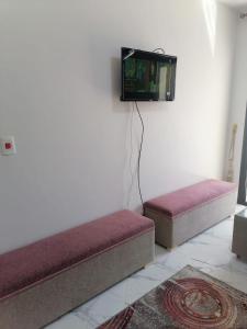 two beds in a room with a tv on the wall at شالية غرفة ورسيبشن وحمام ومطبخ عمارة 4 الدور الأول in Port Said