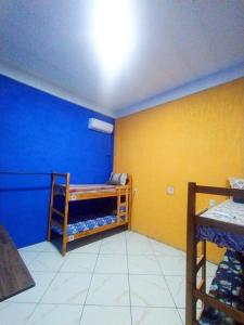 Cette chambre est dotée d'un mur bleu et jaune avec des lits superposés. dans l'établissement Cantinho Iluminado e Relaxante Privativo, à Brasilia