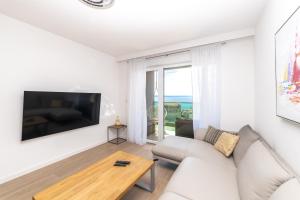 a living room with a couch and a tv and a table at Luxury Apartments Sunny Side in Makarska