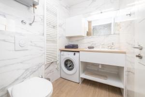 a white bathroom with a washing machine in it at Luxury Apartments Sunny Side in Makarska +43 photos