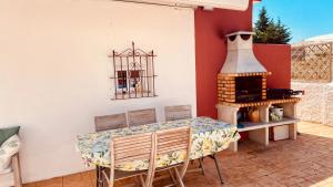 a patio with a table and a fireplace at Casa Rural Colibrí in El Puerto de Santa María