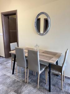 een eettafel met stoelen en een spiegel bij Penelope's apartment ΙΙΙ in Potamiá