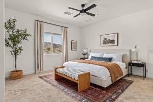 een slaapkamer met een bed en een plafondventilator bij Sunstone Pool, Hot Tub & Mountain Views! in Yucca Valley