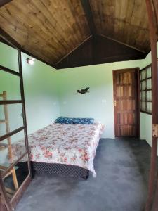 a bedroom with a bed and a wooden ceiling at Chalé Floresta Toca da Serra in Iporanga