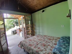 a bedroom with a bed and a sliding glass door at Chalé Floresta Toca da Serra in Iporanga