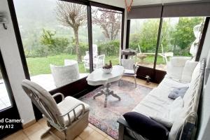 a living room with a table and chairs and a large window at Malpas125 chambres chez l'habitant in Accons