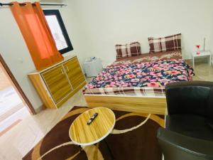a bedroom with a bed and a table and a chair at RESIDENCE EL HADJI in Dakar