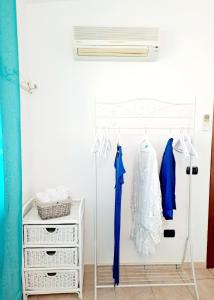 Una habitación con un armario con un vestido y un ventilador. en Casa Flo, en Villasimius