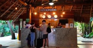 zwei Personen stehen in einer Bar in einem Restaurant in der Unterkunft Tukan Hotel Playa del Carmen in Playa del Carmen