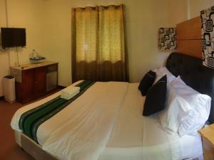 een groot bed in een kamer met een televisie bij Kwarto's in Siquijor
