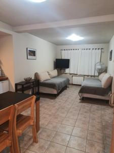 sala de estar con 2 camas y sofá en Las Golondrinas departamento en San Martín de los Andes
