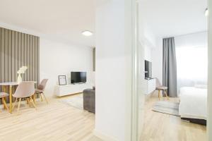Un dormitorio con una cama y un comedor con una mesa. en Himson-Grey Apartment, en Iaşi