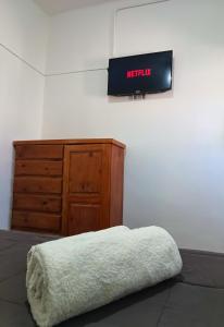 ein Schlafzimmer mit einem Bett und einer Holzkommode in der Unterkunft Hotel Estrella Andina in San Juan