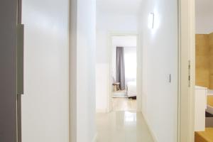 Un pasillo que conduce a un dormitorio con paredes blancas. en Himson-Grey Apartment, en Iaşi 48 fotos más