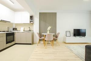 Una cocina y un comedor con mesa y sillas. en Himson-Grey Apartment, en Iaşi