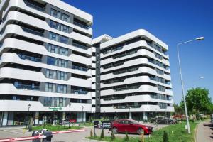 Un coche rojo aparcado delante de un edificio en Himson-Grey Apartment, en Iaşi