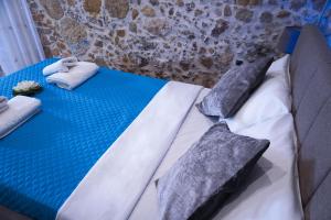 niebiesko-białe łóżko z poduszkami w obiekcie Cozy Stonehouse in Κissamos w mieście Kerá