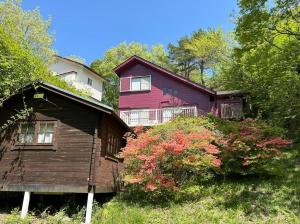 una casa con una casa roja y un árbol en ヴィンテージ那須, en Nasu