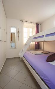 a bedroom with a bunk bed with purple sheets at Lavanda in Tribunj